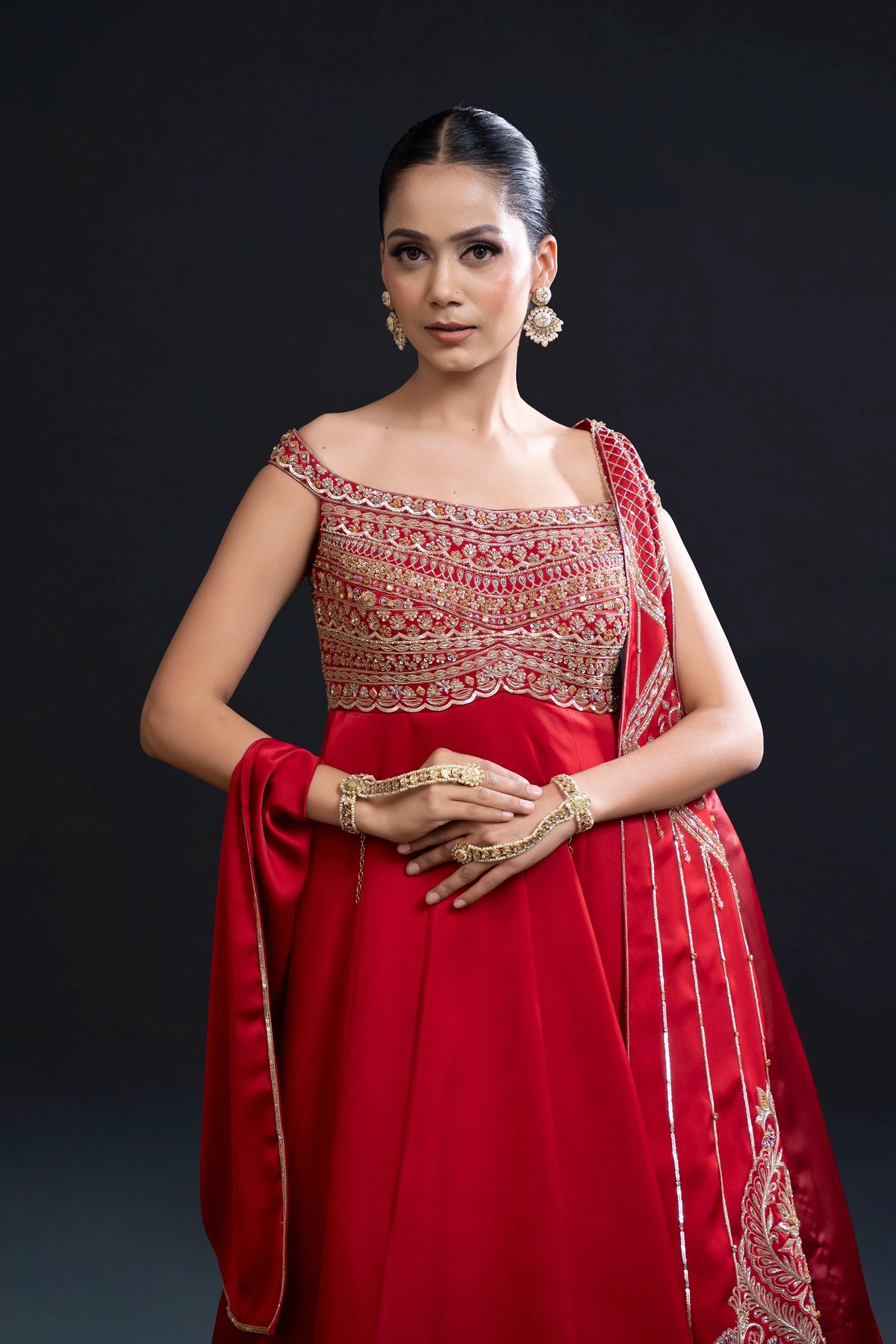 Woman in a red traditional outfit with intricate patterns on a black background