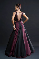 Woman wearing a two-tone dress with open back on a dark background