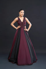 Woman wearing a burgundy and black evening gown against a dark background