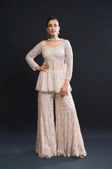 Woman wearing a beige lace outfit against a black background