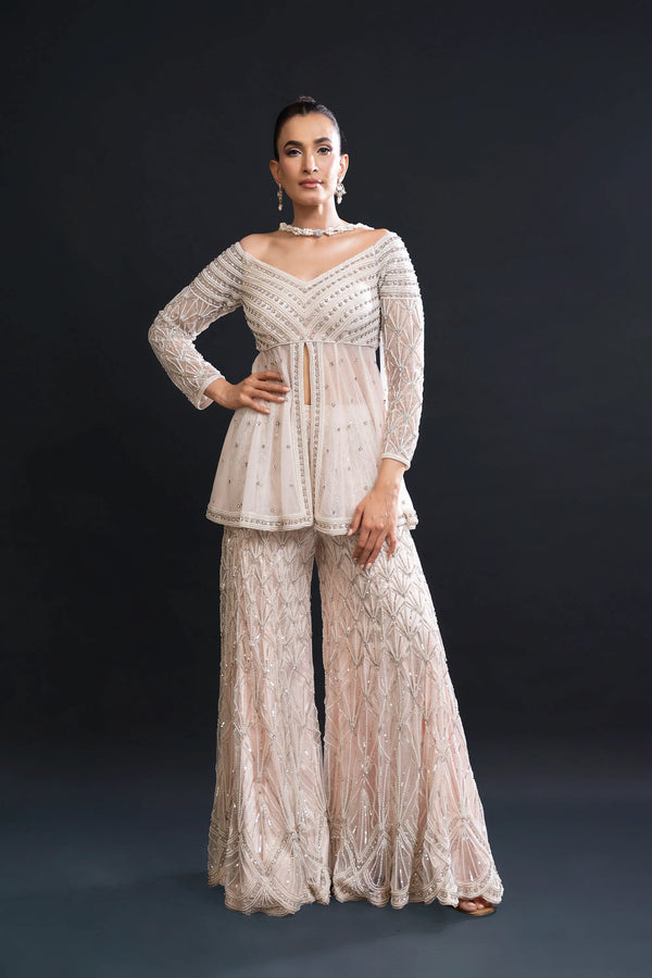 Woman wearing a beige lace outfit against a black background