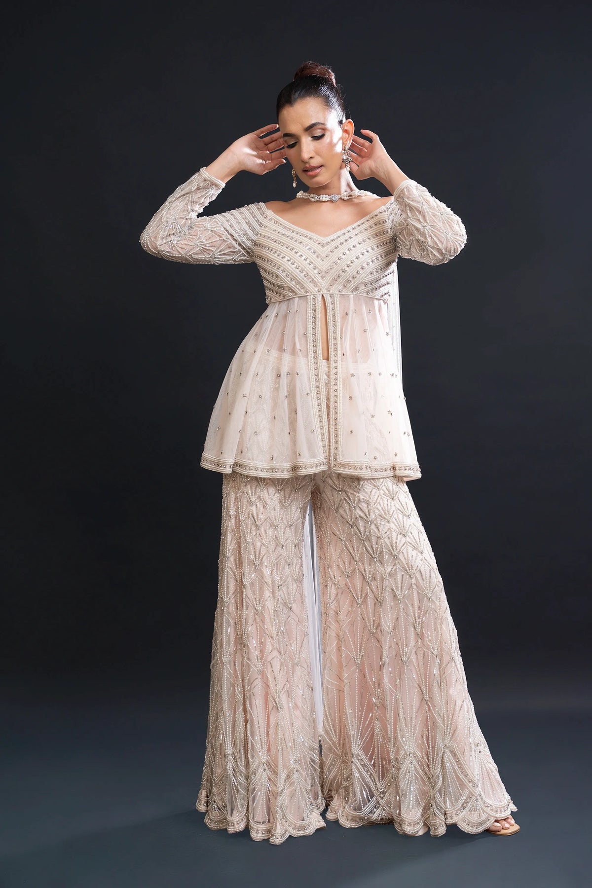 Woman wearing a beige lace outfit against a black background